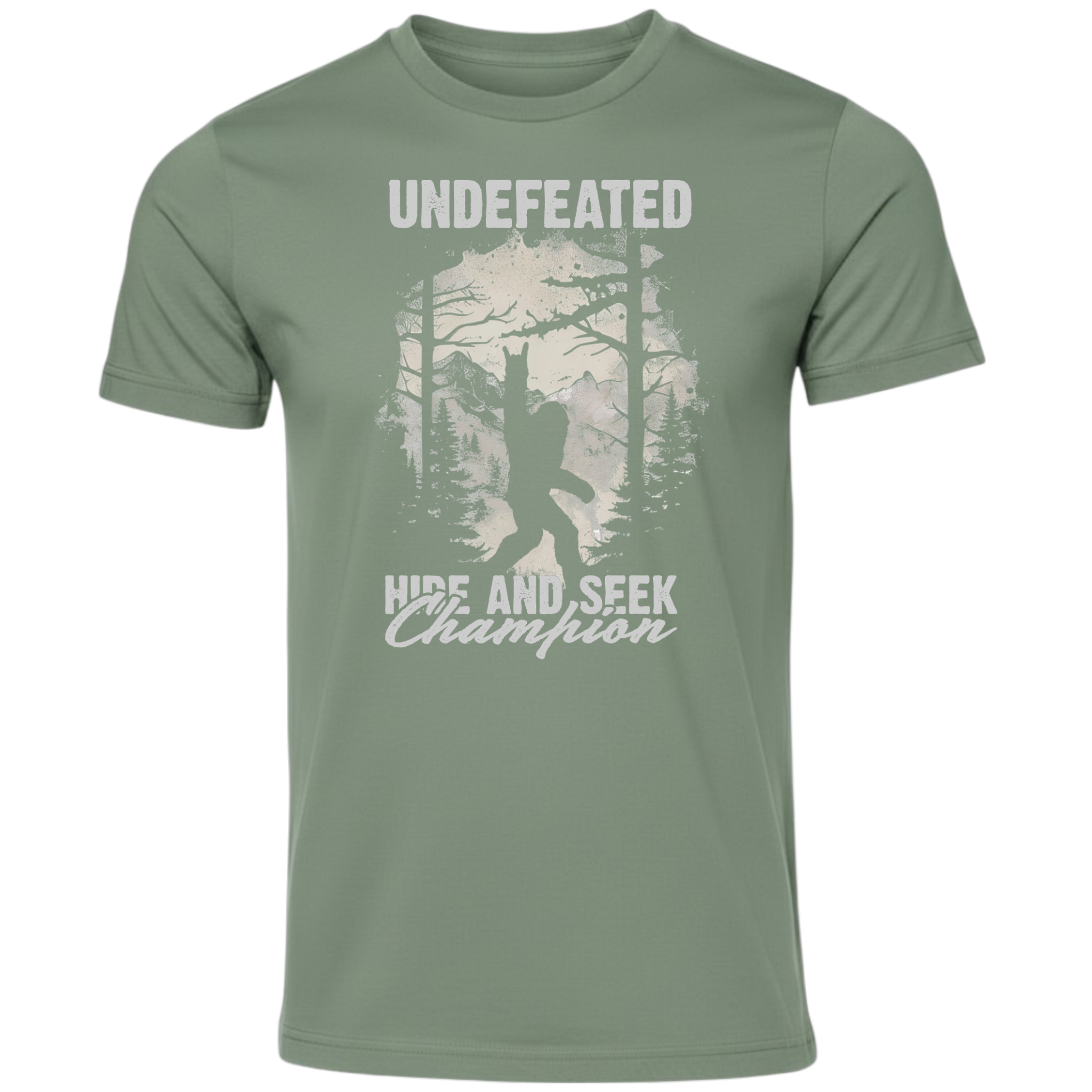 An olive green short-sleeve t-shirt with a distressed white graphic on the front featuring a Bigfoot silhouette in a forest and the text 'UNDEFEATED' and 'HIDE AND SEEK Champion'.