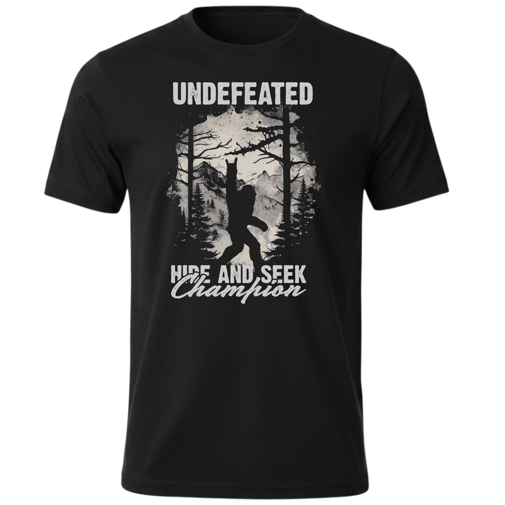 A black short-sleeve crewneck t-shirt featuring a light grey graphic print of a Bigfoot silhouette in a forest, with the text 'UNDEFEATED' above and 'HIDE AND SEEK Champion' below.