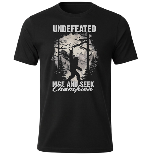 A black short-sleeve crewneck t-shirt featuring a light grey graphic print of a Bigfoot silhouette in a forest, with the text 'UNDEFEATED' above and 'HIDE AND SEEK Champion' below.